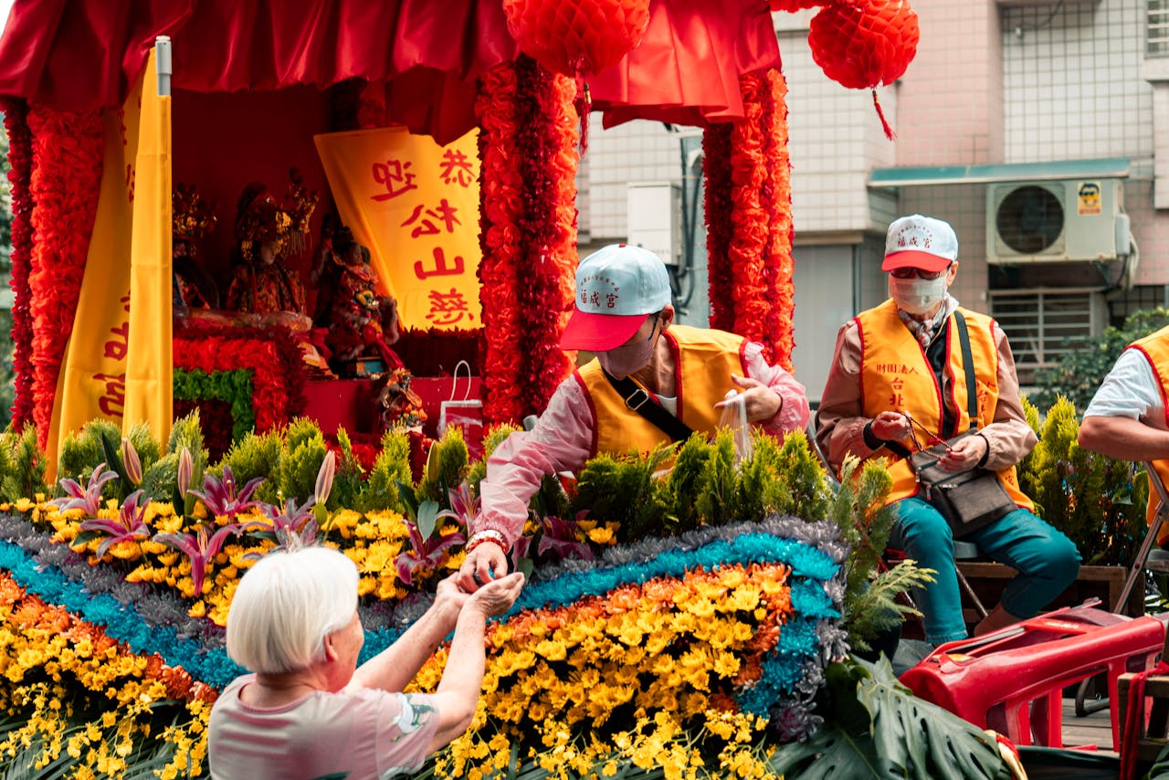 A colorful parade scene with people and floral decorations, showcasing cultural festivities.
